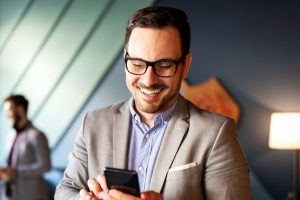 Handsome Businessman Checking Emails On The Phone In Modern Office | Navazon Digital