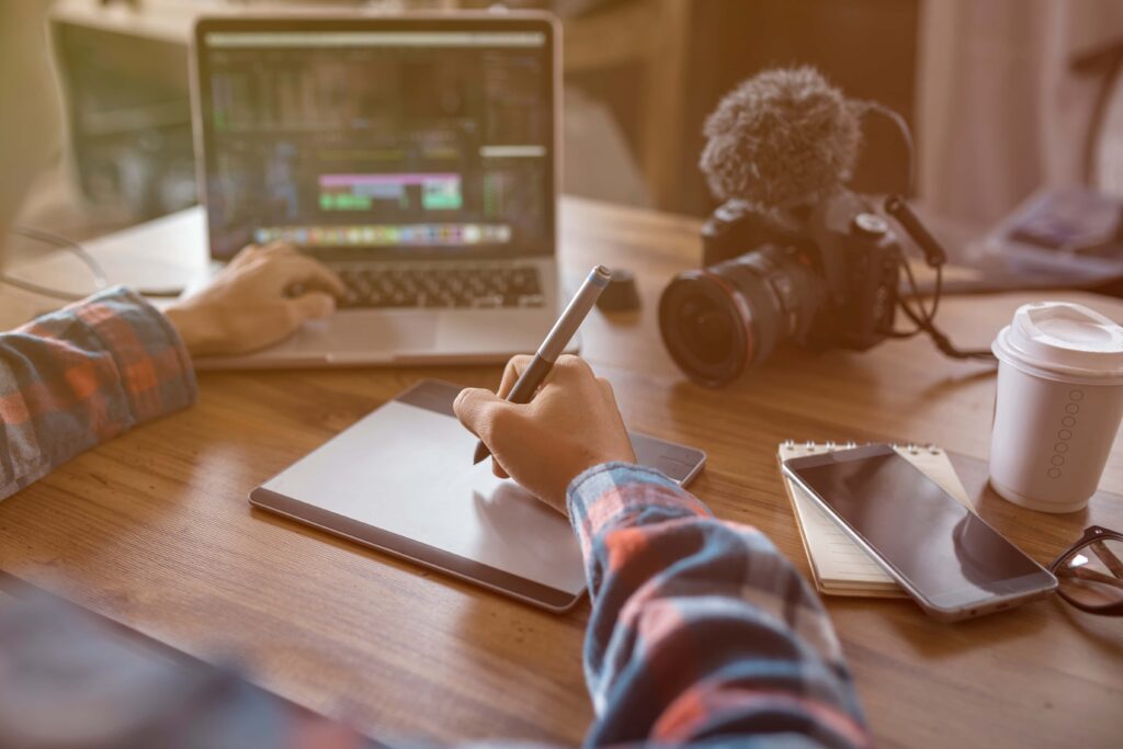 Digital Marketing Video Production arms of a man working on his tablet and working on a video production with a video camera on the camera | Navazon Digital