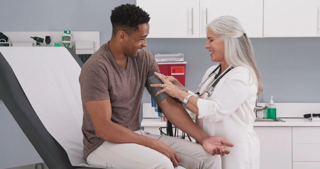 Mature white female physician checking male patients blood pressure at clinic | Navazon Digital Mature white female physician checking male patients blood pressure at clinic | Navazon Digital